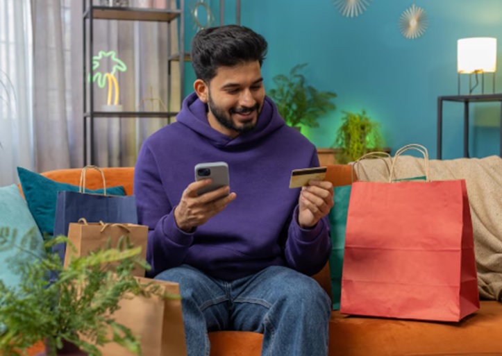 A man is holding his new phone and an Insta EMI card.
